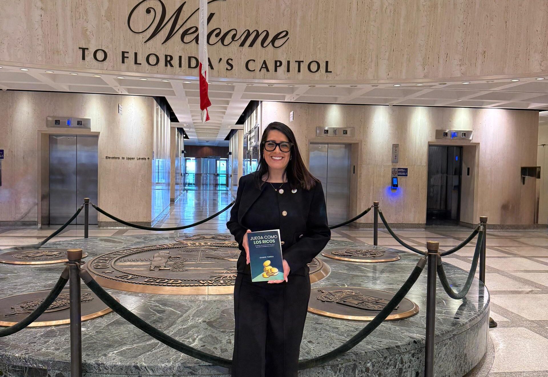 Isamar Torres con su libro "Juega como los ricos" durante la entrega del Premio Líder Internacional.