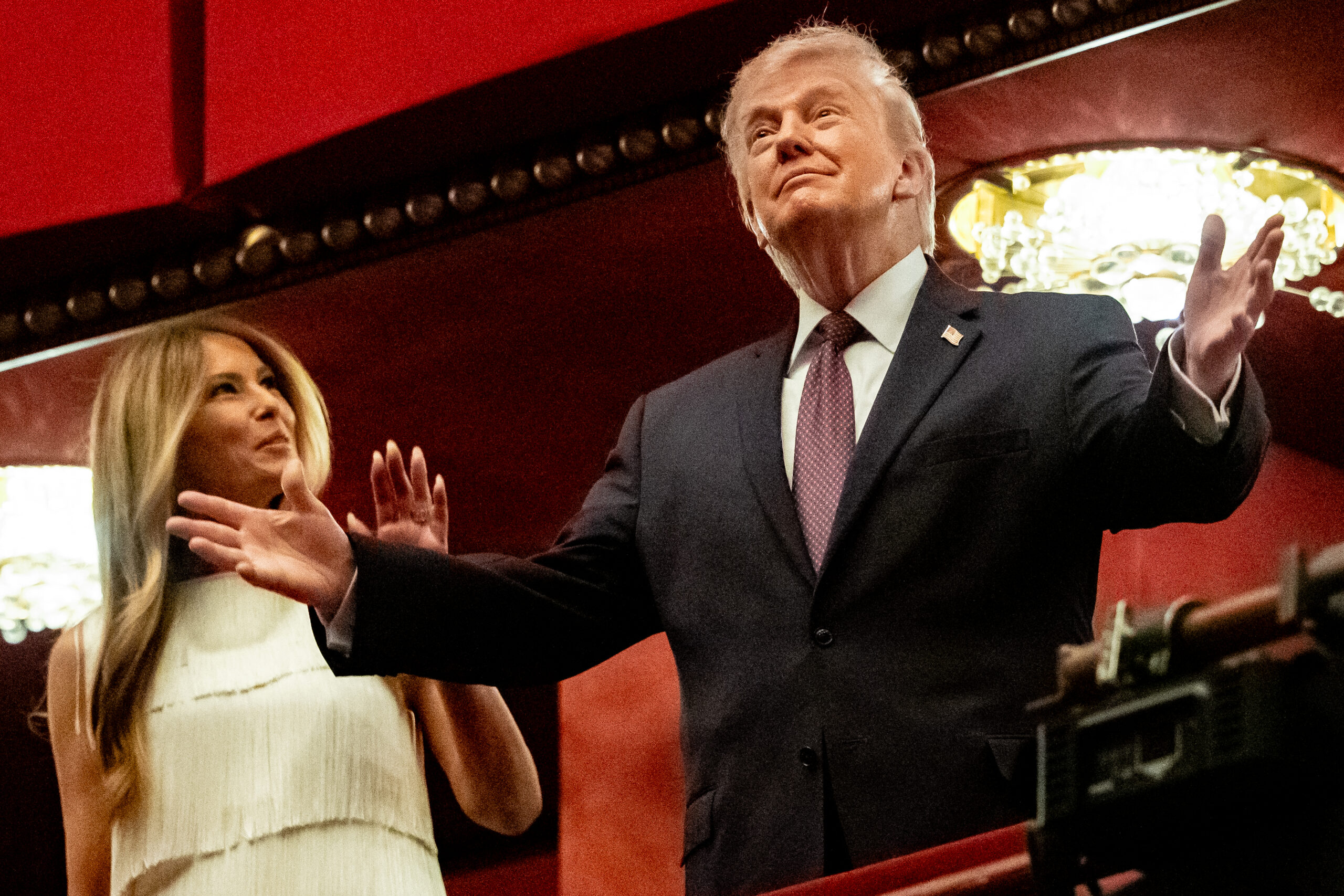 Donald Trump de pie con un fondo de la bandera de Venezuela.