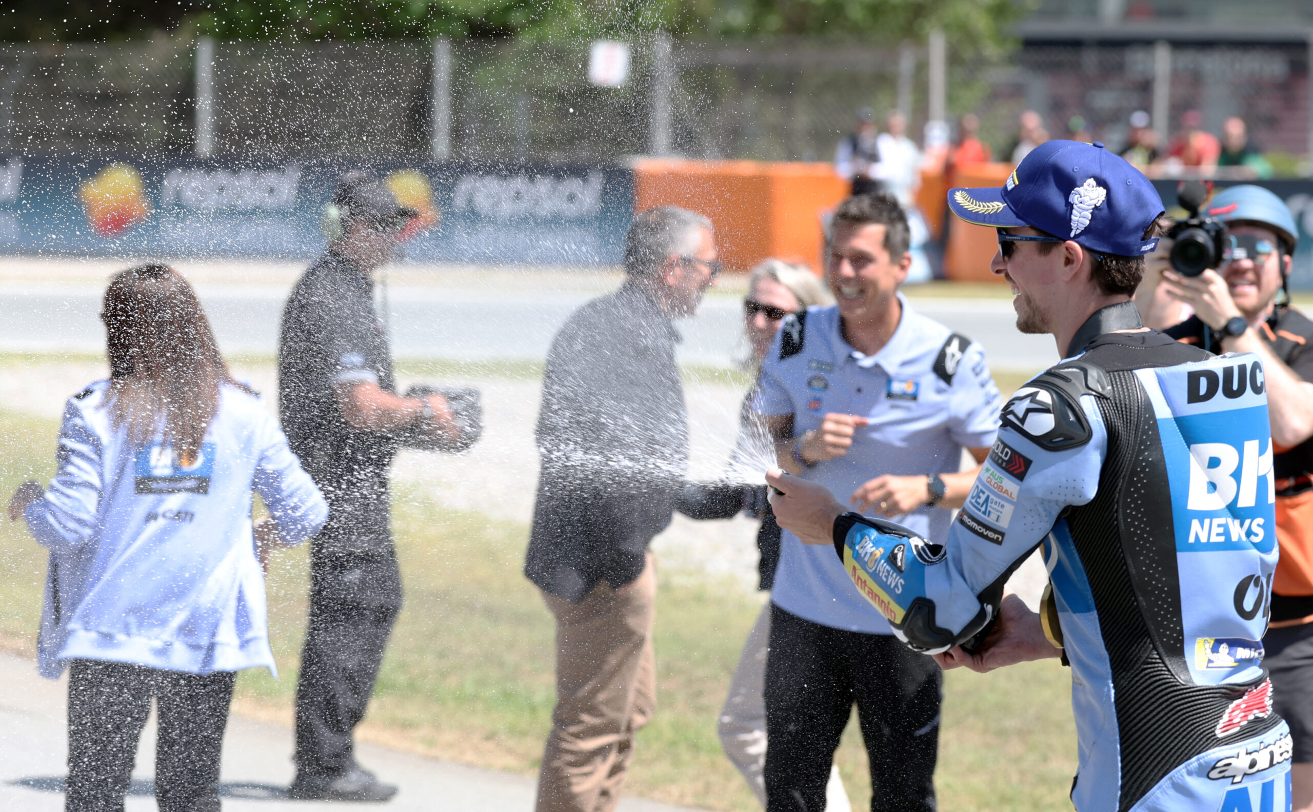 Álex Márquez levantando los brazos en celebración tras ganar la carrera esprint en Cataluña.