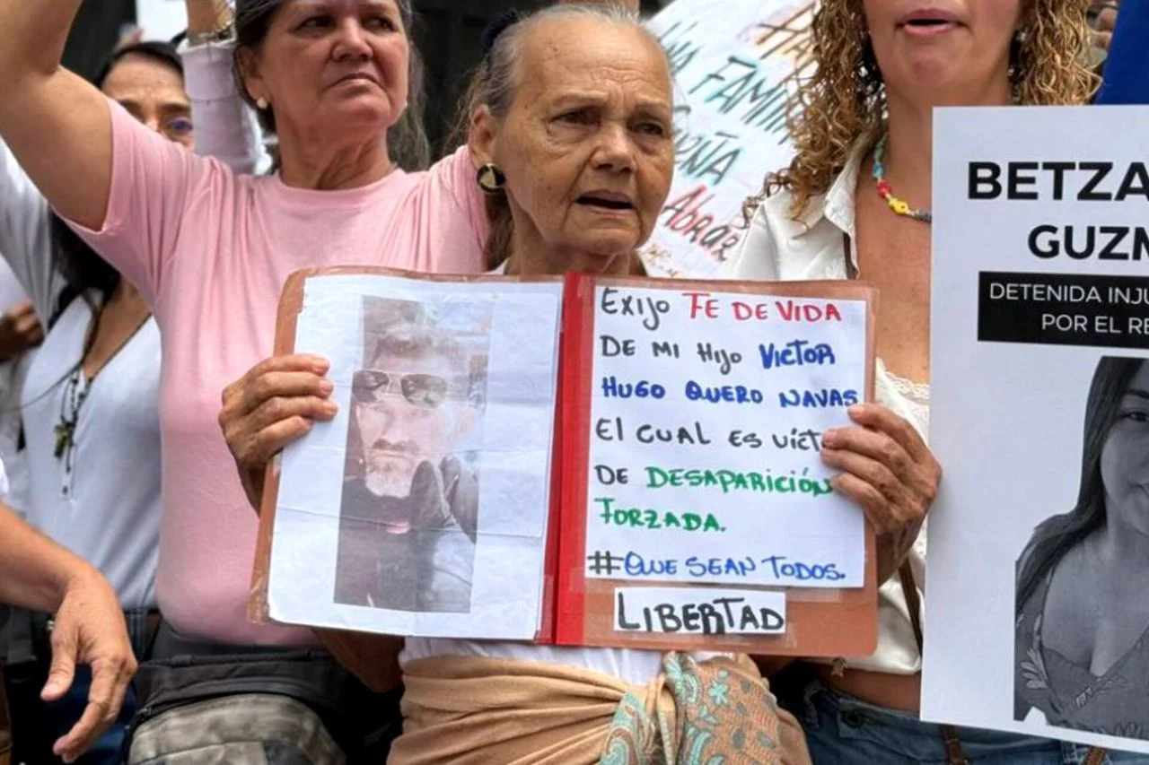 Carmen Teresa Navas, madre de Víctor Quero, sosteniendo una fotografía de su hijo durante una protesta en Venezuela.