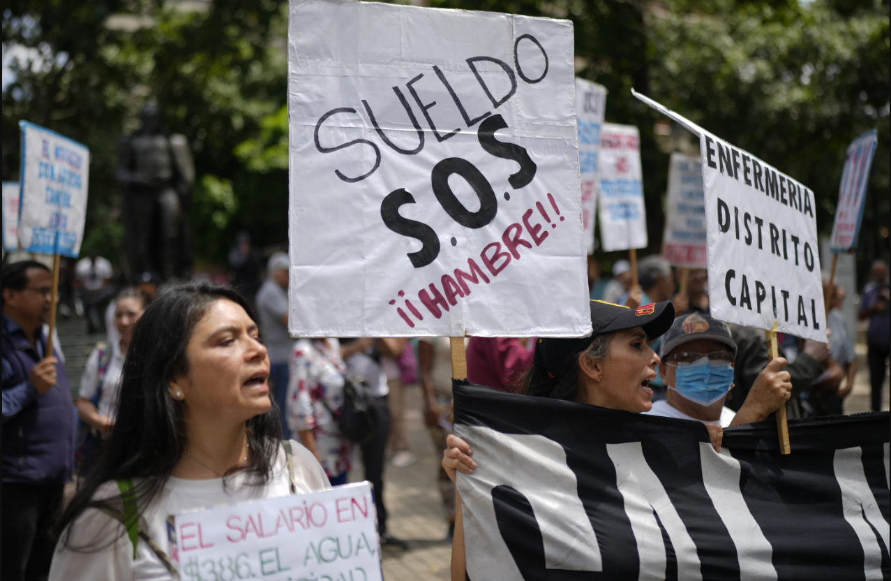 Un grupo de trabajadores sindicalizados en Venezuela sosteniendo pancartas y exigiendo mejoras salariales.