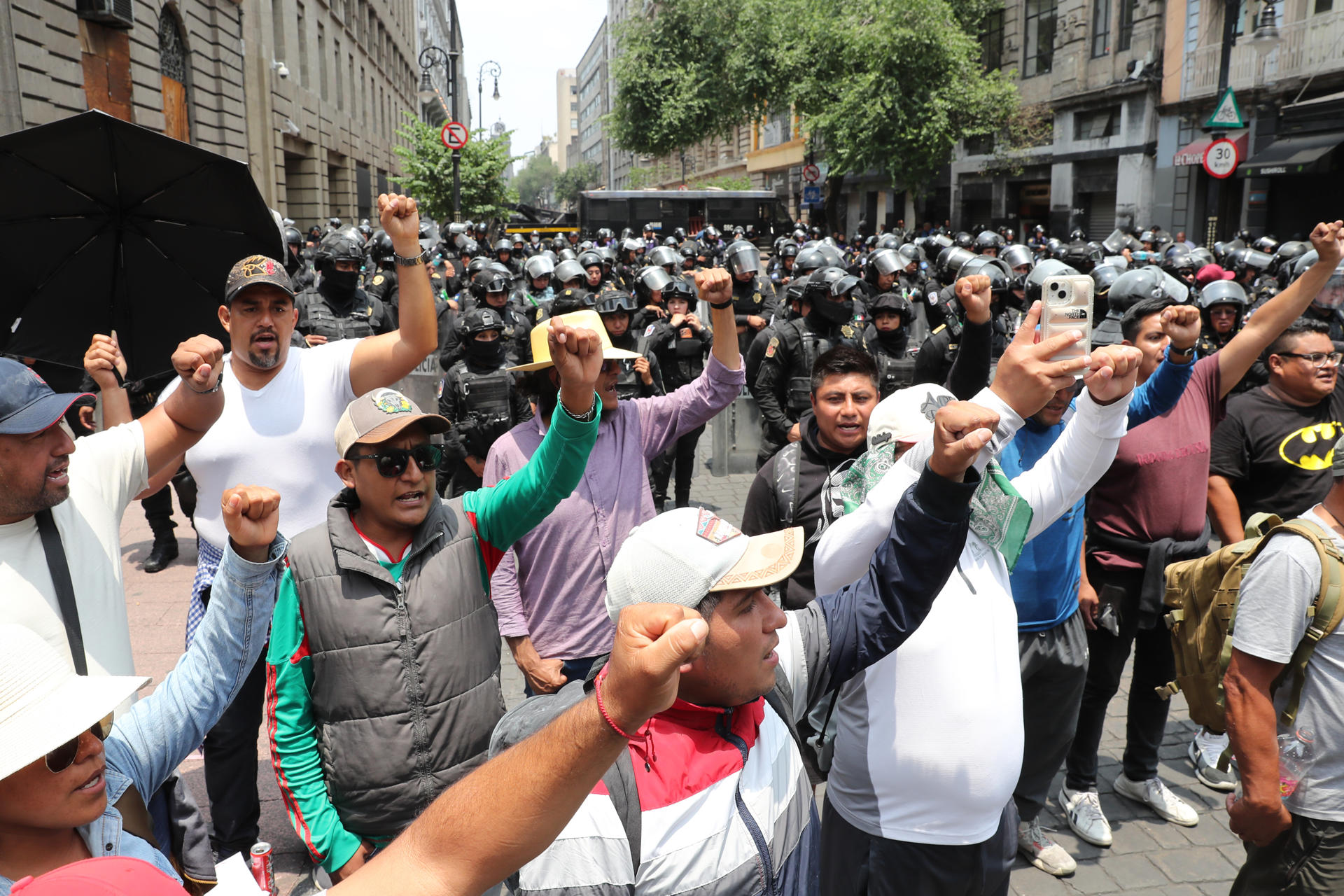 Policías antimotines mexicanos con escudos y equipo antidisturbios enfrentan a un grupo de manifestantes en la Plaza de la Constitución, conocida como el Zócalo, en la Ciudad de