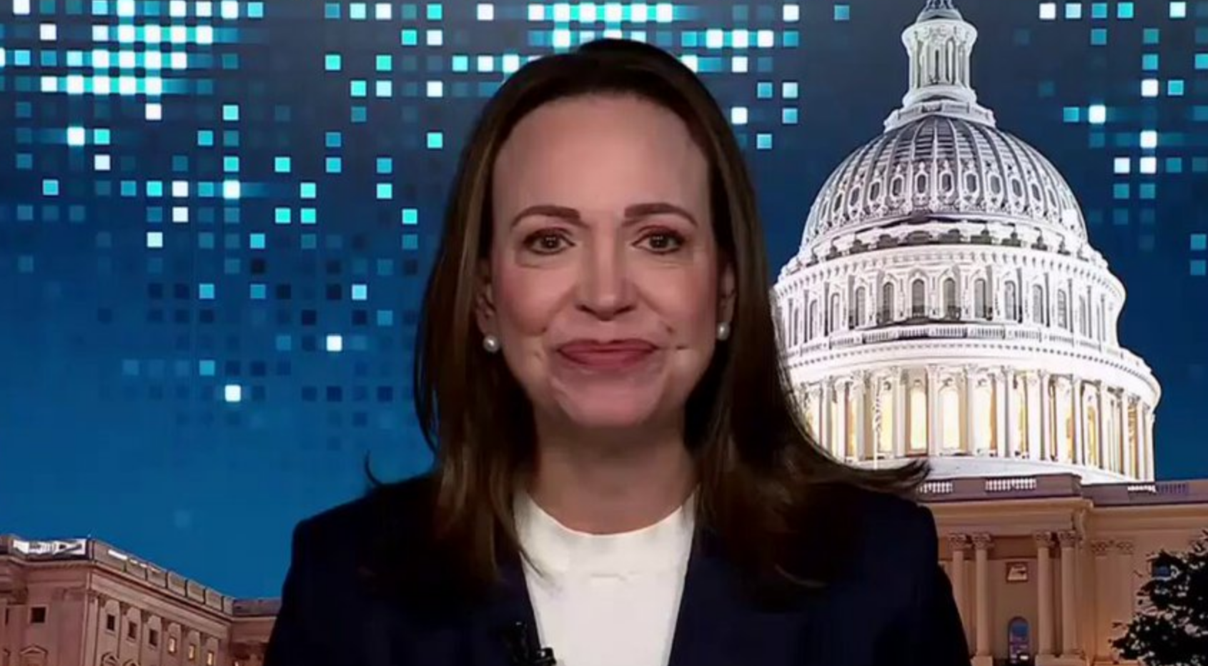 María Corina Machado hablando en una conferencia de prensa, con un micrófono delante.