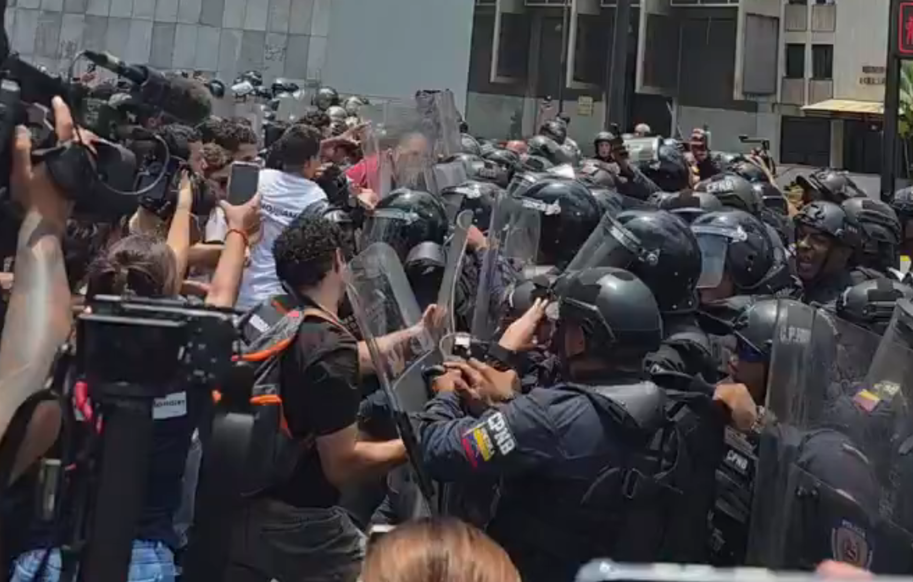 Estudiantes universitarios confrontando a agentes de la PNB durante una protesta en Plaza Venezuela.