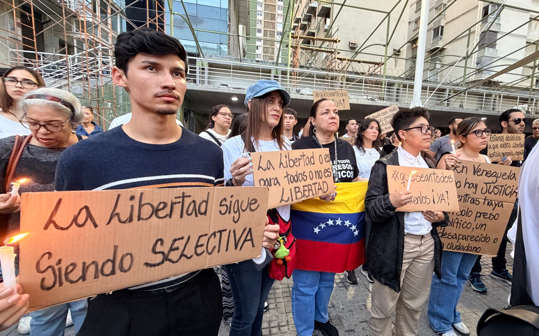 Ciudadanos encendiendo velas y portando carteles durante una vigilia en la Plaza de Los Palos Grandes, Chacao.
