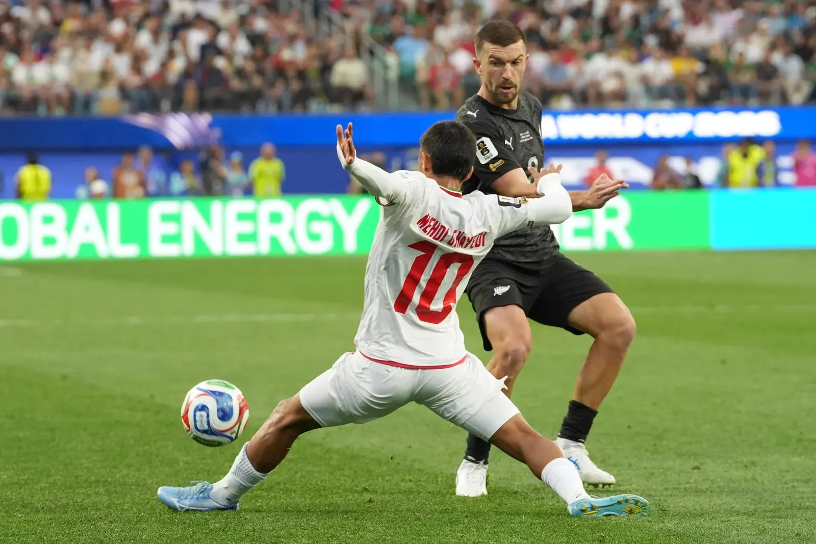 Aficionados iraníes con banderas prerrevolucionarias observan un partido de fútbol del Mundial 2026 entre Irán y Nueva Zelanda.