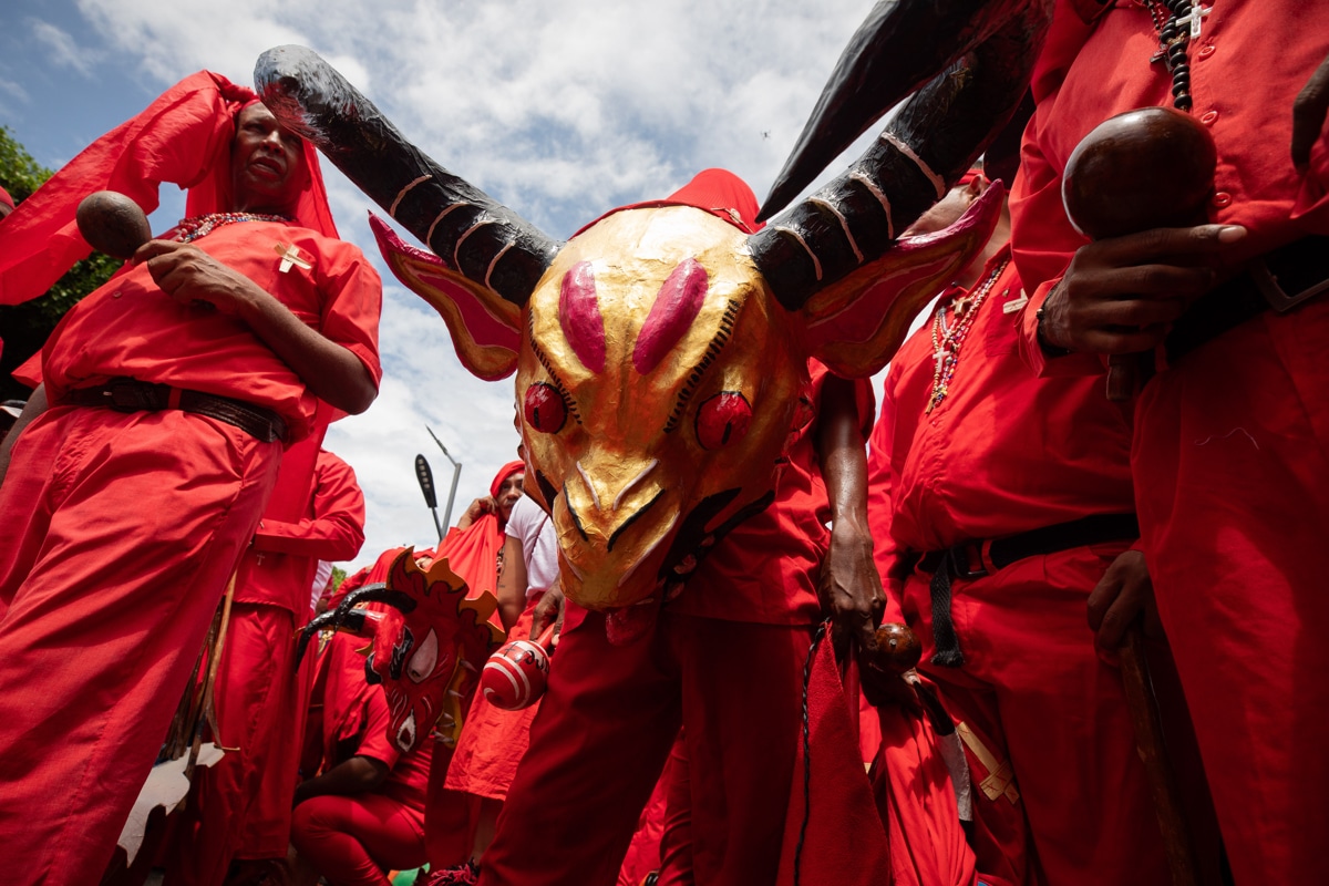 Cientos de personas con máscaras y vestimentas rojas participan en la procesión de los Diablos Danzantes de Yare.