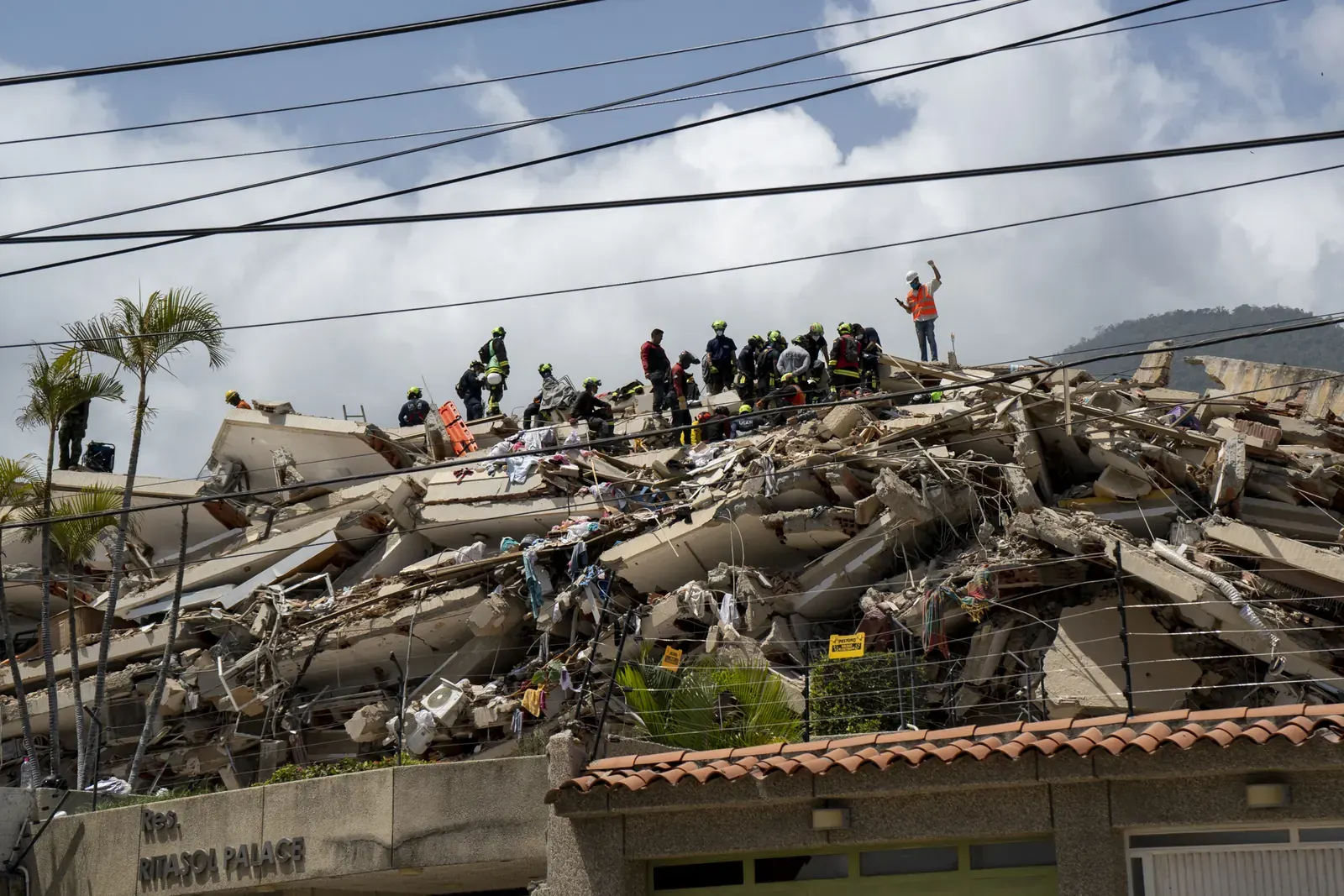 Equipos de rescate internacionales colaboran en La Guaira en la búsqueda de sobrevivientes tras un devastador terremoto, con personal y unidades caninas inspeccionando estructuras