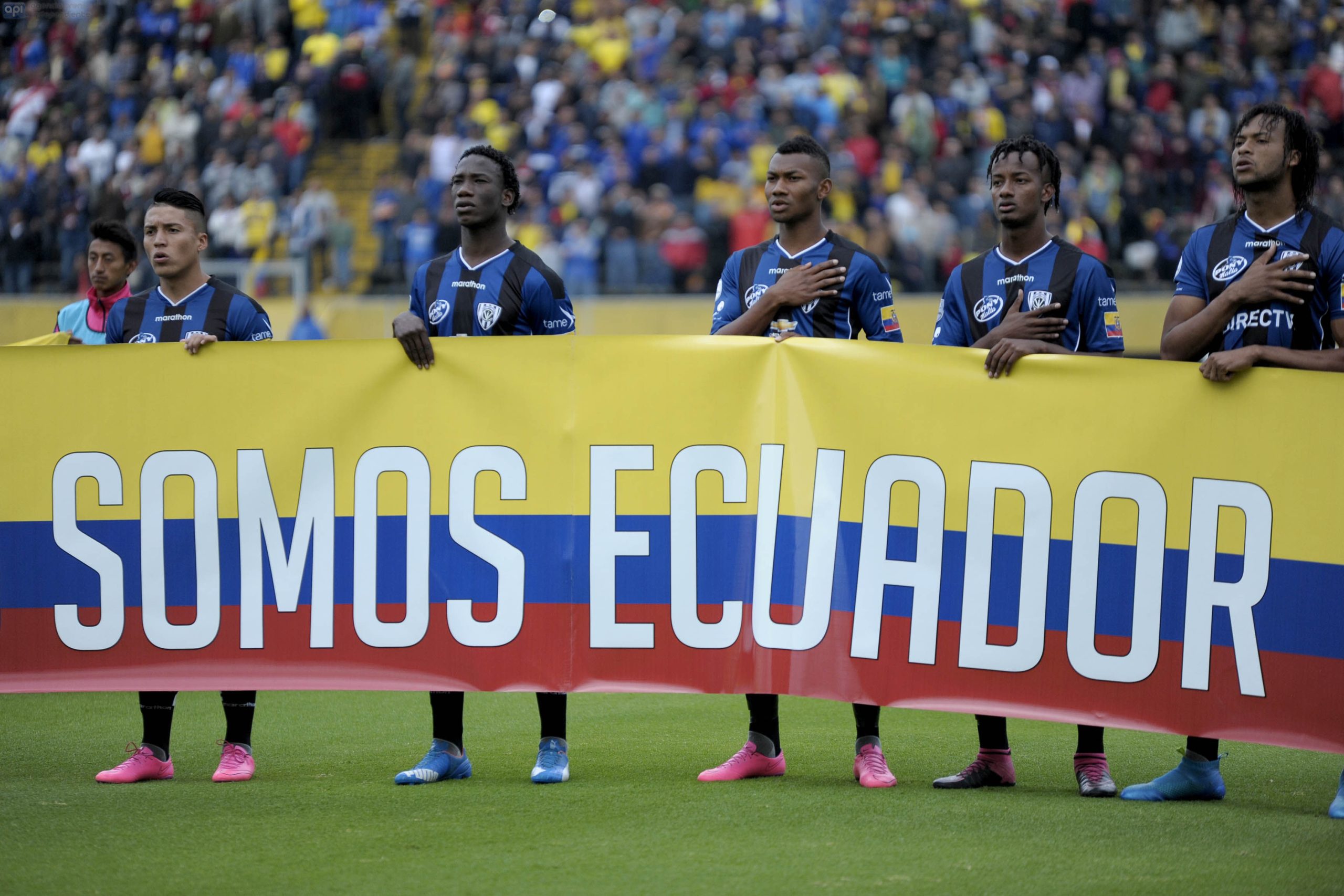 Jugadores de fútbol de diferentes selecciones nacionales celebrando en un estadio en Venezuela.