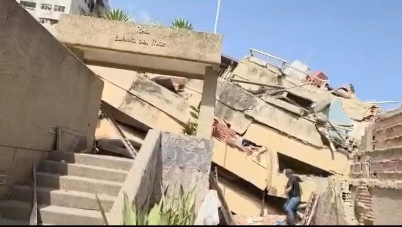 Padre removiendo escombros con esperanza de encontrar a su hijo en un edificio derrumbado en La Guaira.