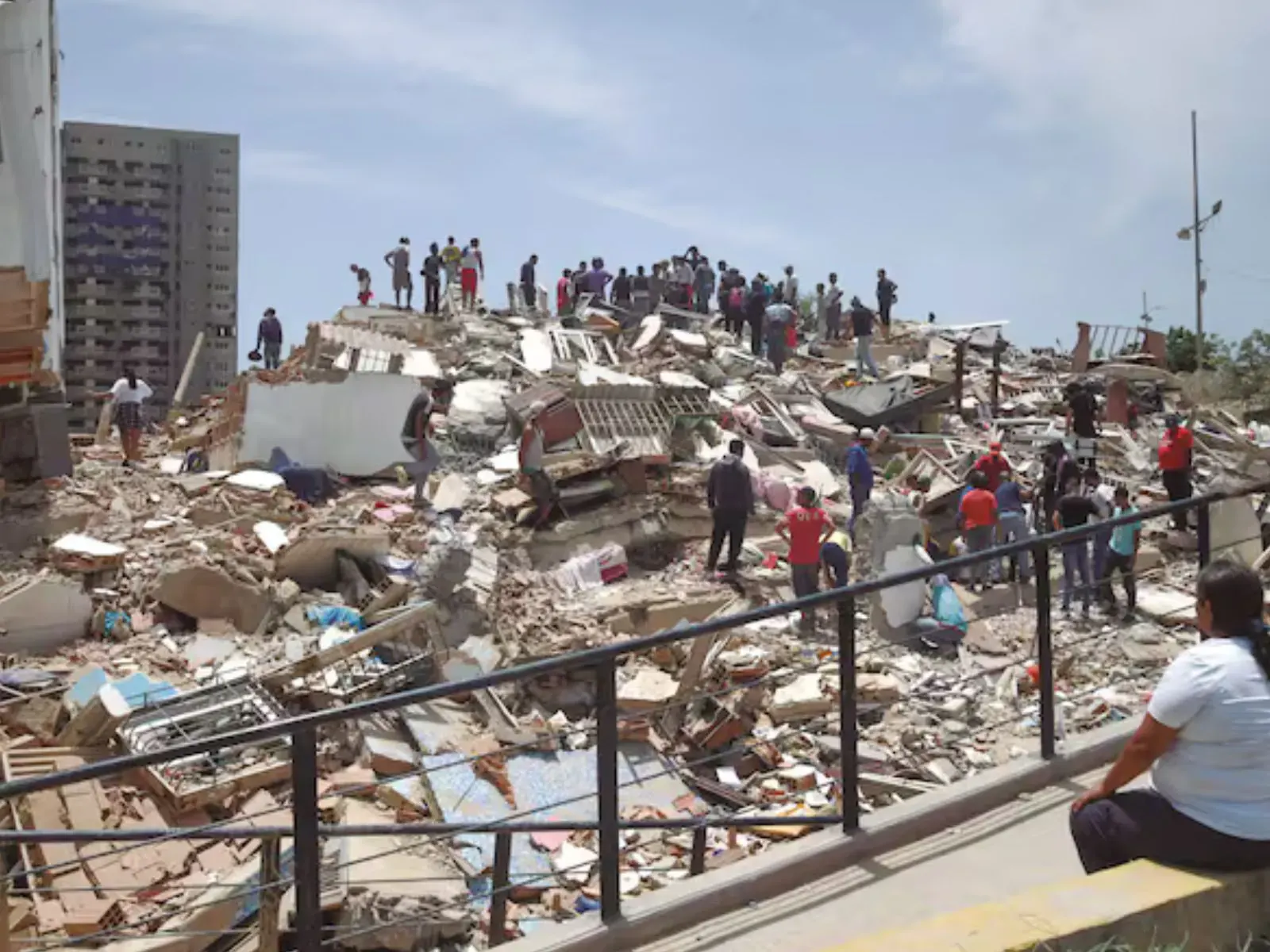 Damnificados en La Guaira buscando agua potable y recibiendo ayuda tras los efectos de un terremoto.