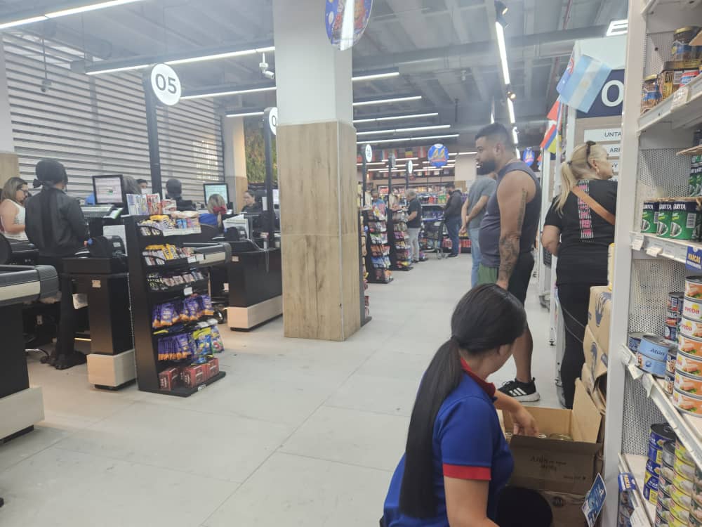 Personas haciendo cola en las afueras de un supermercado en Caracas, Venezuela, tras los sismos, con algunas estructuras mostrando daños.