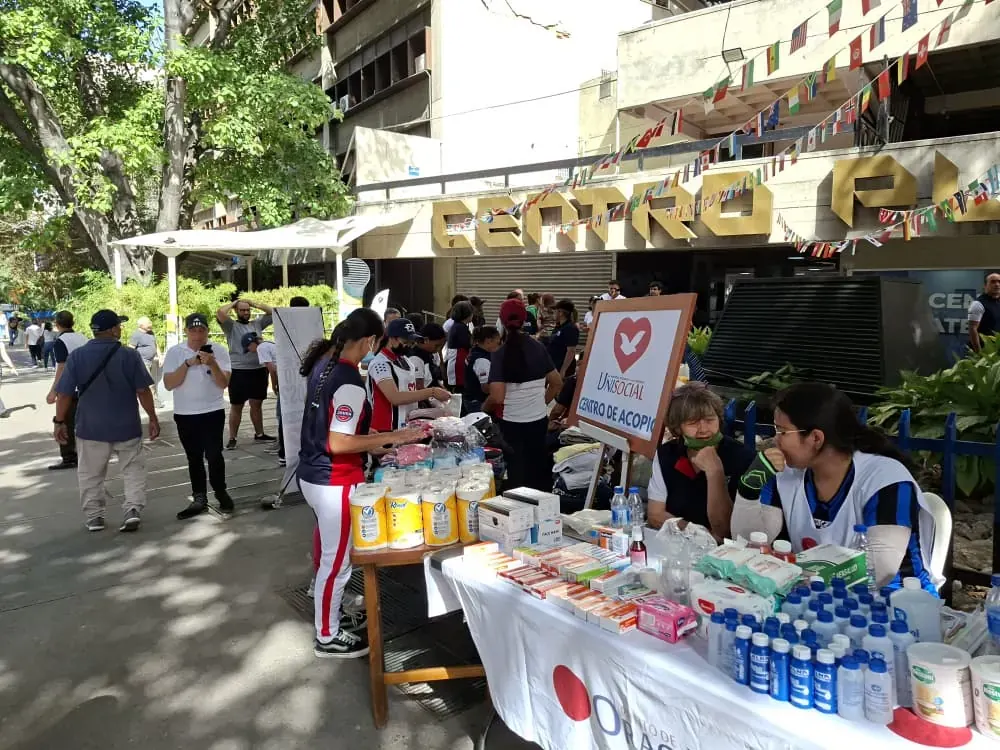 Voluntarios venezolanos organizando donaciones de alimentos y suministros en un centro de acopio tras un terremoto.