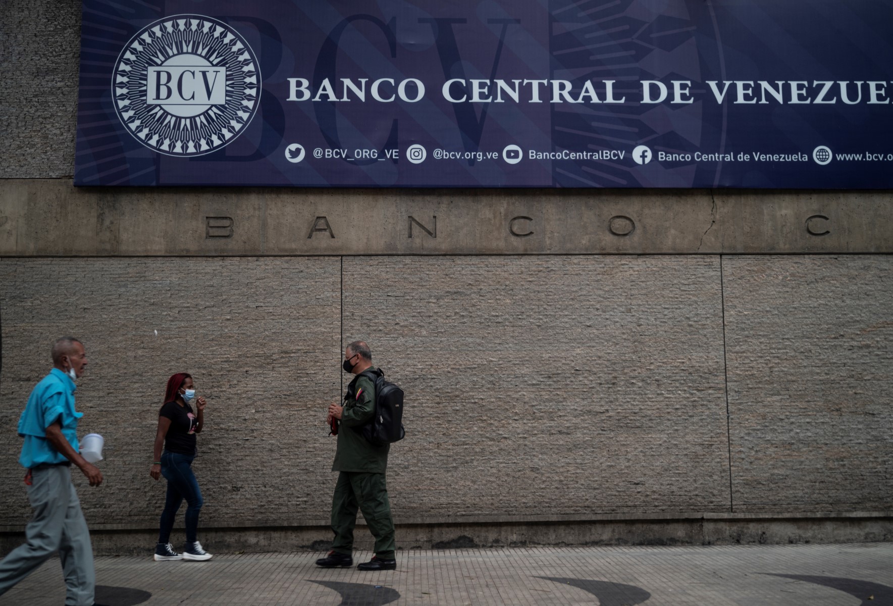 Grupo de economistas discutiendo propuestas sobre la deuda venezolana en un foro en España.