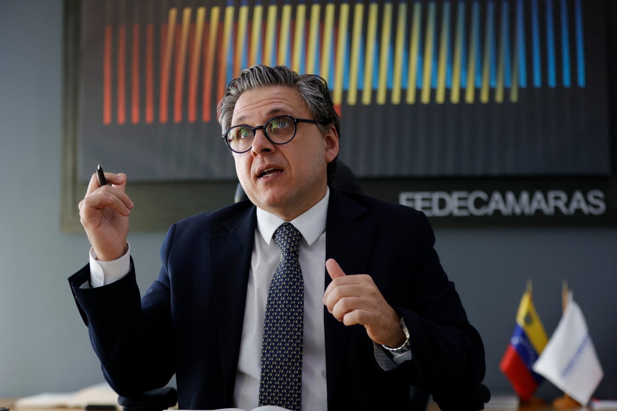 Grupo de empresarios venezolanos analizando datos económicos en una sala de reuniones.