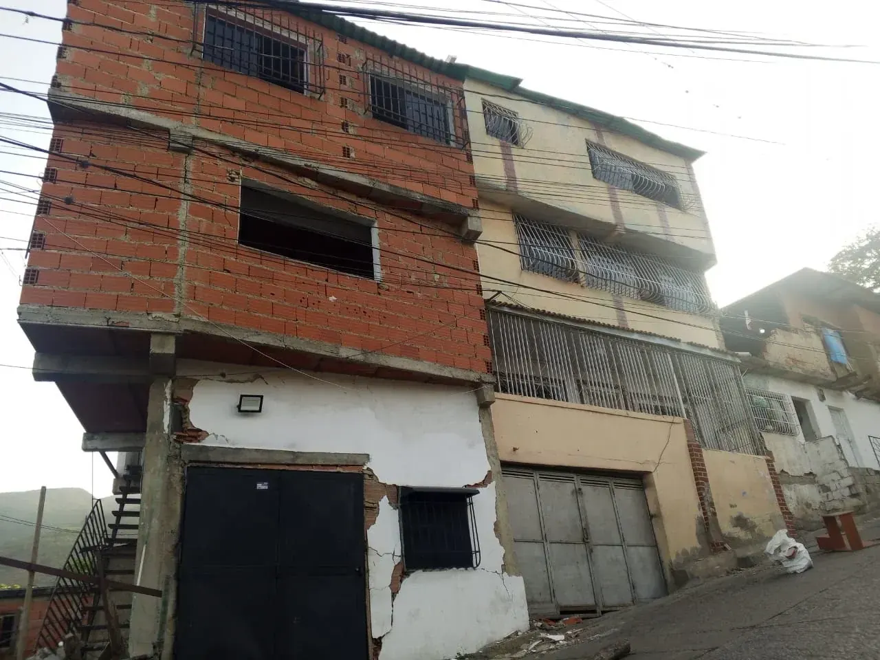 Familias venezolanas pernoctan en la plaza Santa Rita, en la carretera Caracas-La Guaira, por temor al colapso de sus viviendas tras sismos.