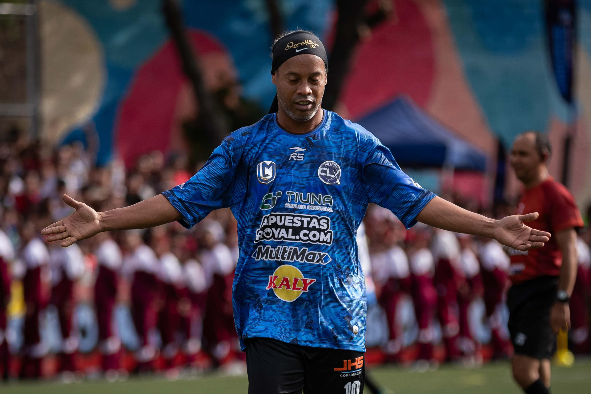 Ronaldinho jugando al fútbol en un partido de exhibición rodeado de jóvenes en Petare, Caracas.