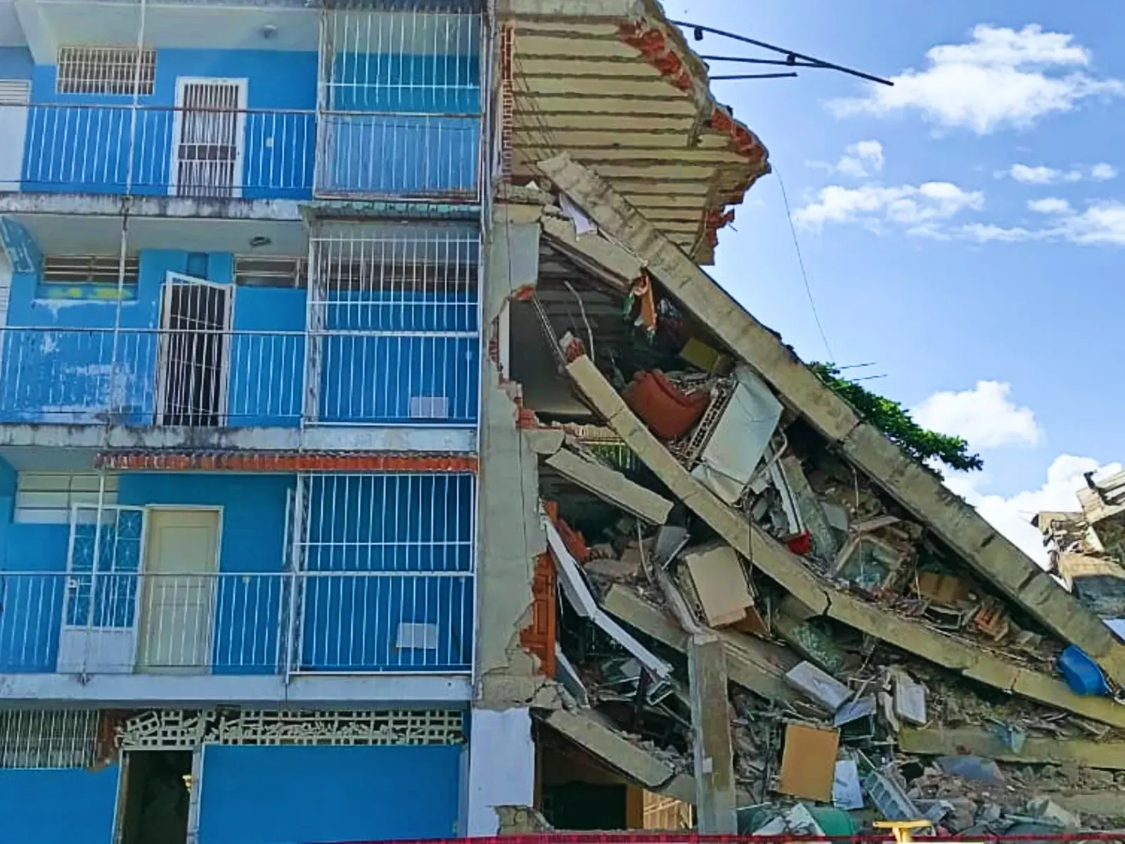 Damnificados venezolanos se resguardan en carpas y lonas dentro de un estadio deportivo en Guarenas, cubiertos con mantas y rodeados de sus pertenencias, tras sufrir daños en sus