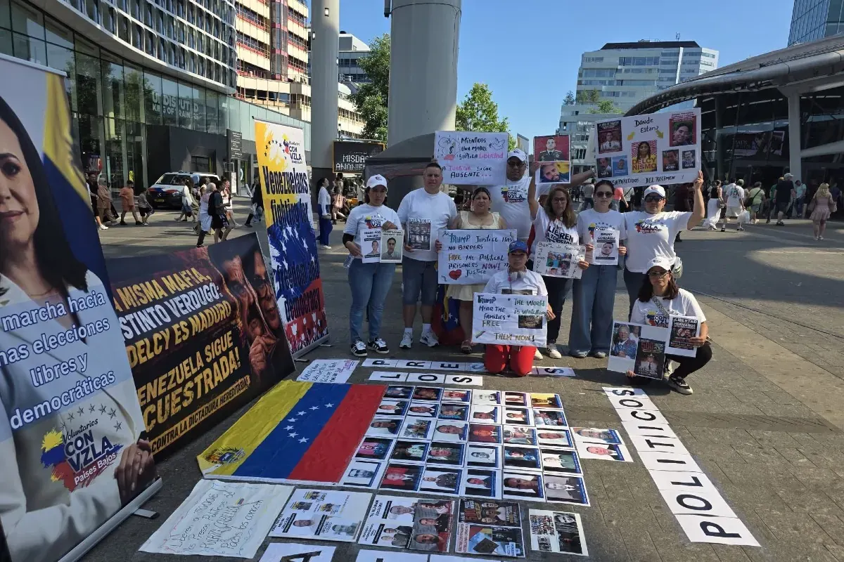 Venezolanos sostienen pancartas y retratos de presos políticos durante una manifestación en la Estación Central de Utrecht, Países Bajos.