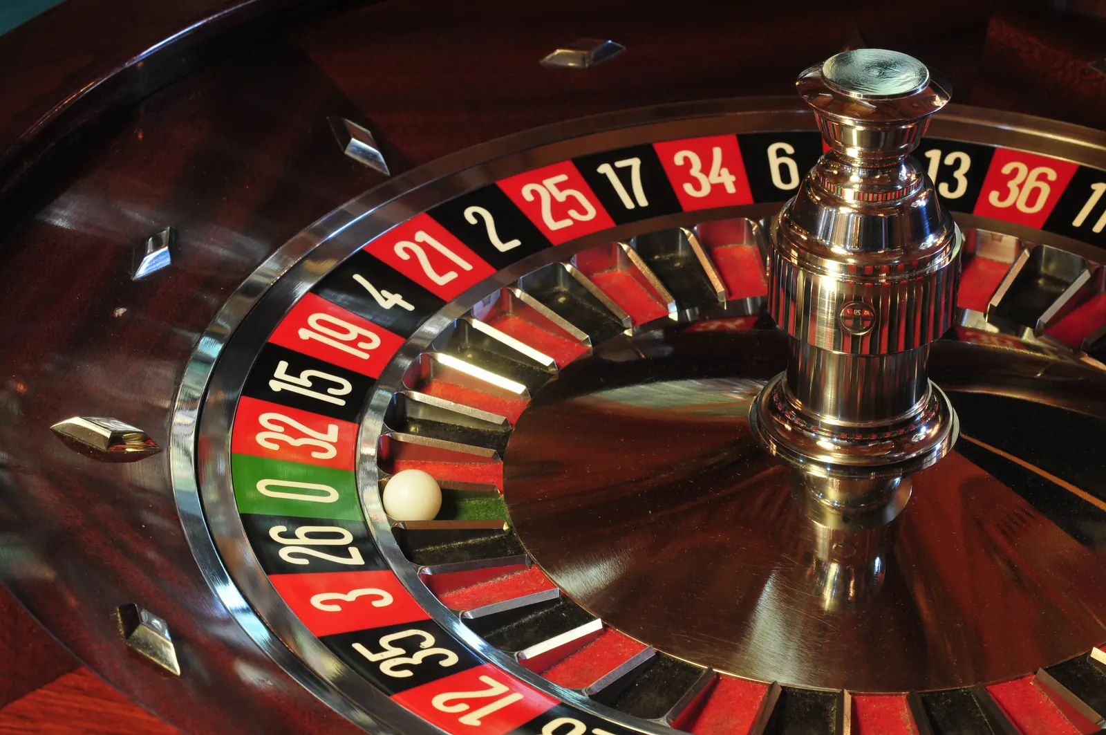 Un primer plano de una ruleta de casino con fichas y una bola en movimiento, simbolizando el juego responsable.