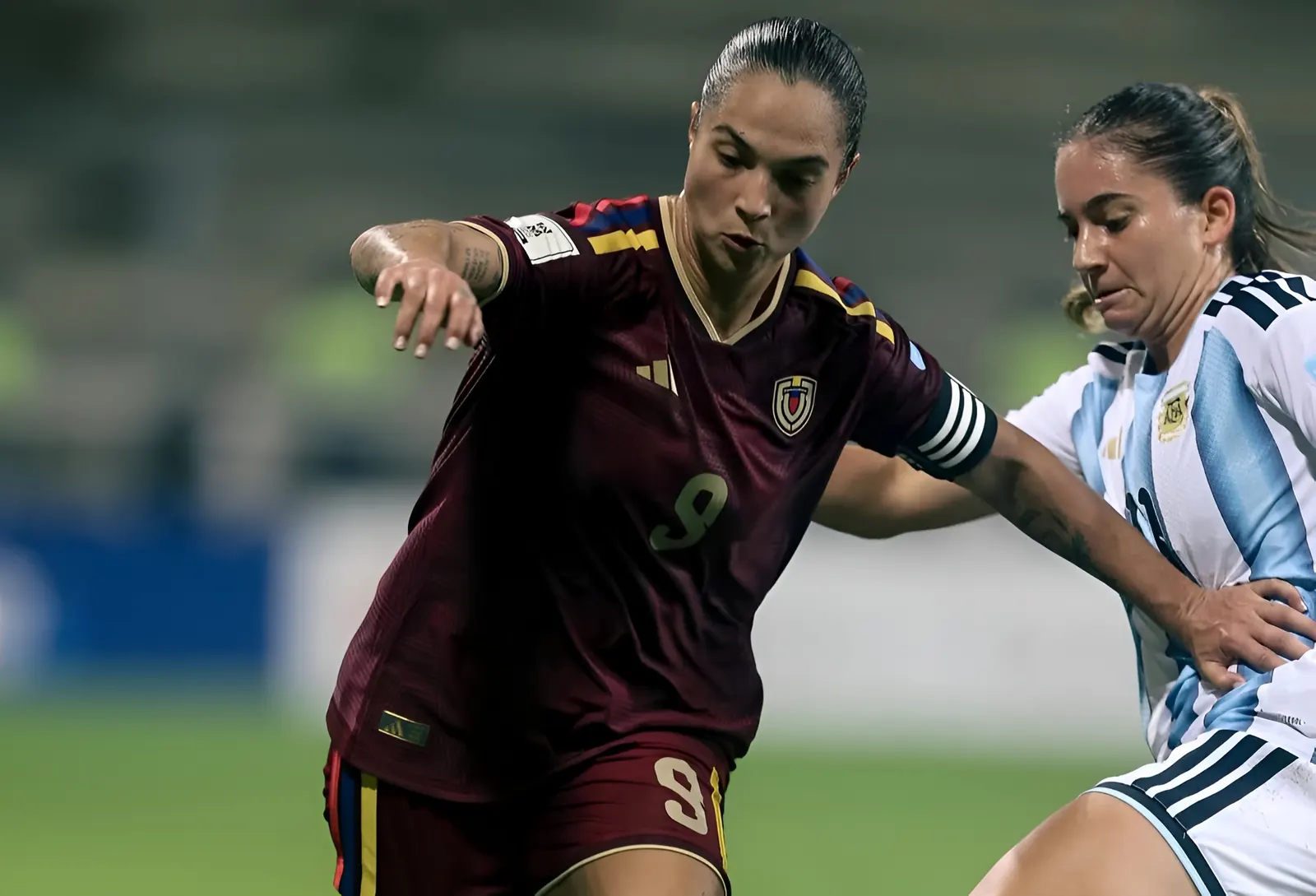 La futbolista venezolana Deyna Castellanos, con expresión seria y compasiva, porta un micrófono.