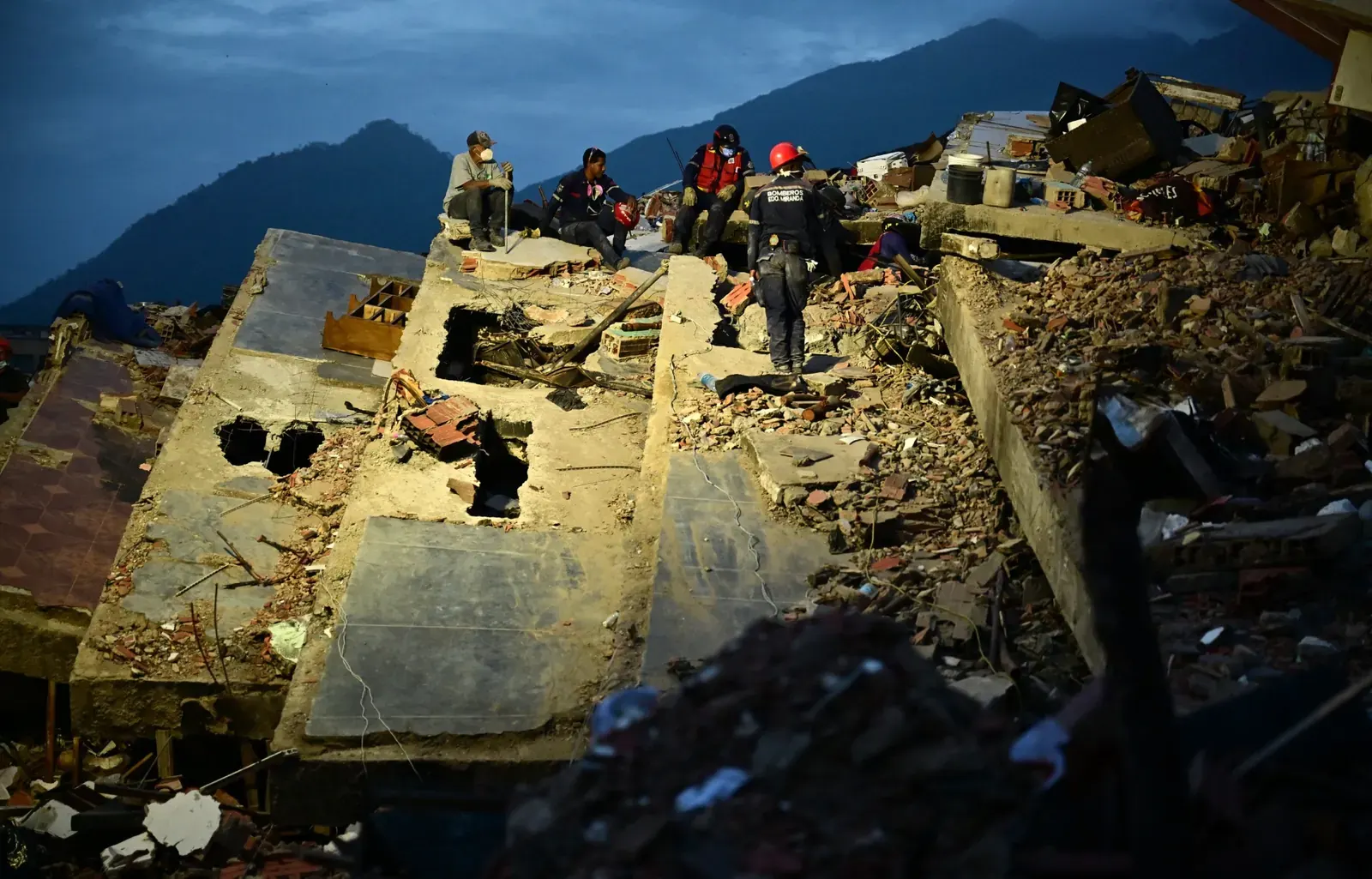 Voluntarios buscan sobrevivientes entre los restos de edificios colapsados tras un terremoto en Venezuela.