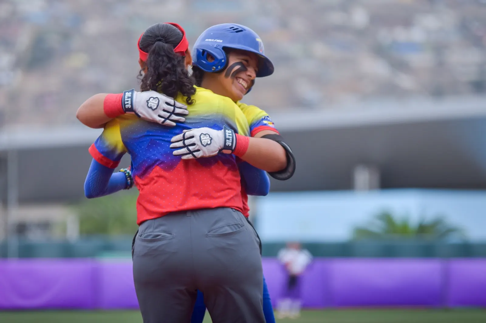 Jugadoras de la selección venezolana de softbol celebran en el campo tras ganar un partido del Mundial de la WBSC.