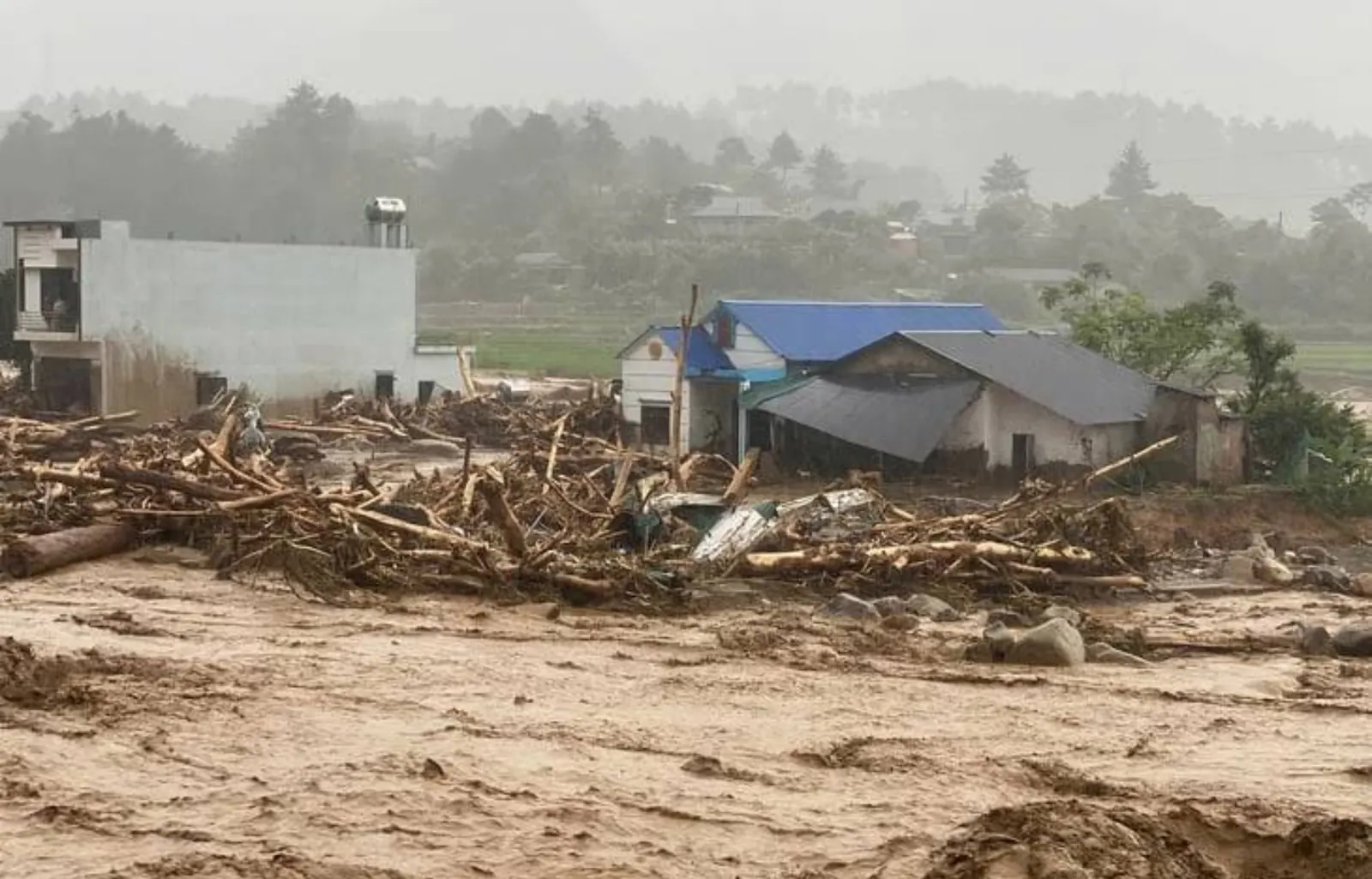 Calle cubierta de lodo y escombros tras una inundación repentina en una aldea de Vietnam.