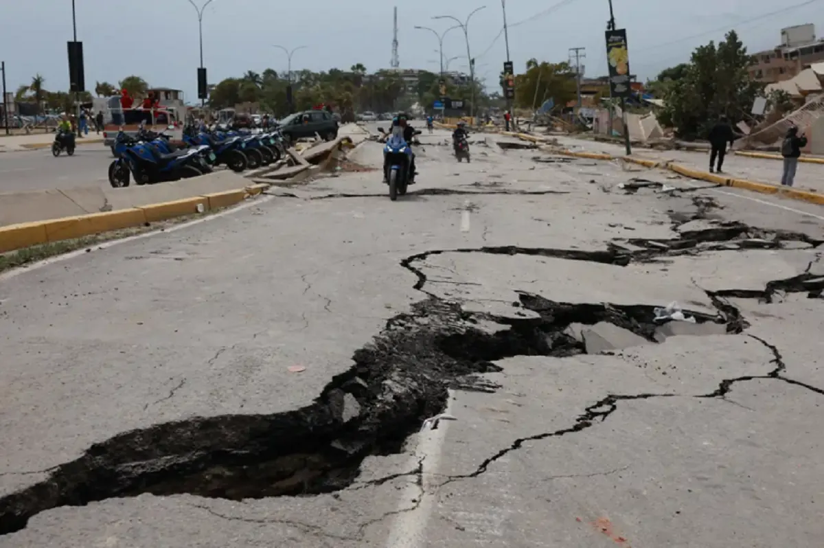 Vista aérea de una autopista con derrumbes y maquinaria trabajando en Venezuela.