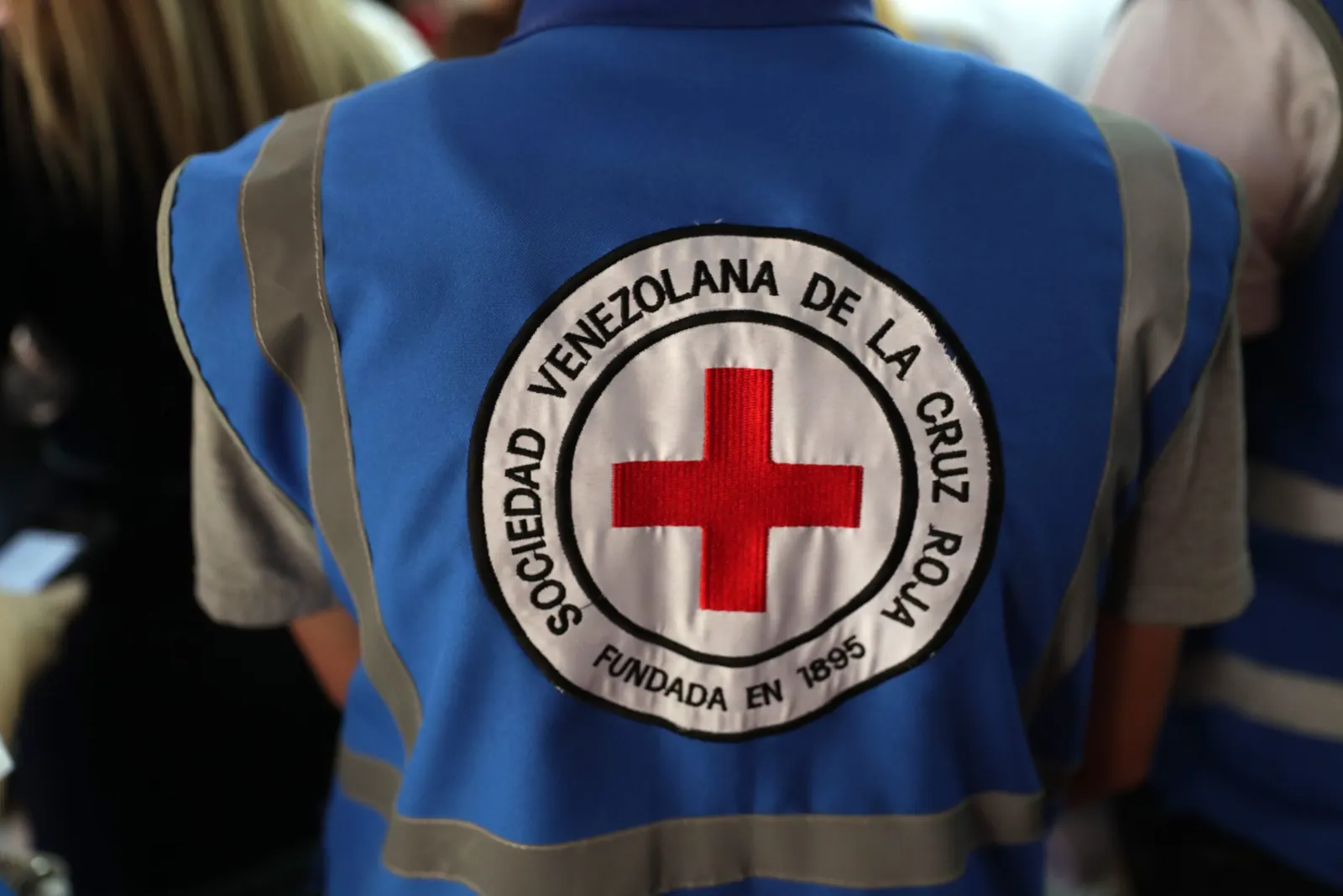 Representantes de la Cruz Roja Venezolana en una oficina, asistiendo a personas que buscan información sobre sus familiares tras los terremotos.