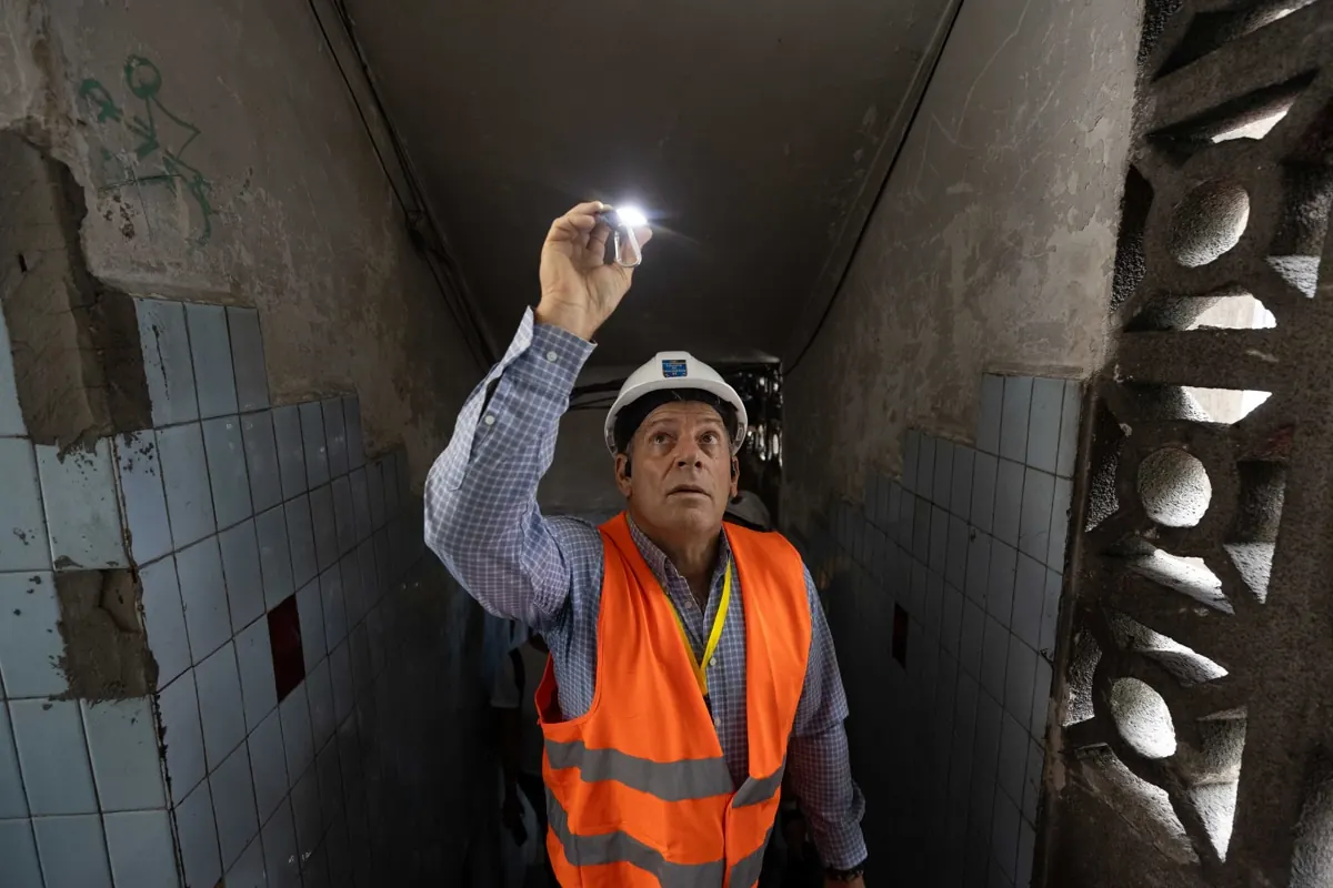 Ingenieros civiles con cascos y chalecos amarillos revisando la estructura de un edificio afectado por un sismo en Venezuela.