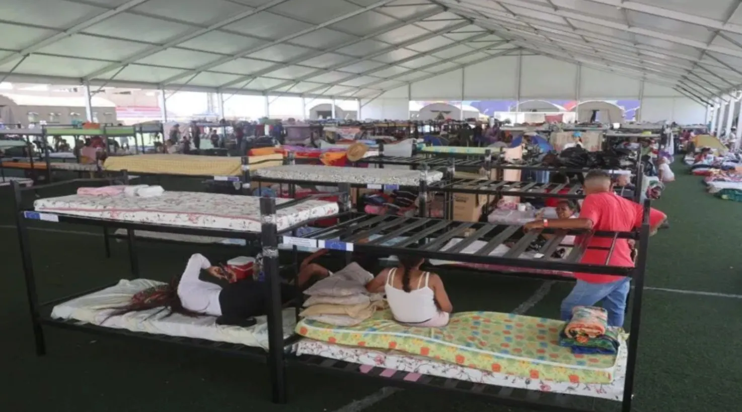 Personas damnificadas por terremotos en Venezuela observando la entrega de materiales de construcción para viviendas.