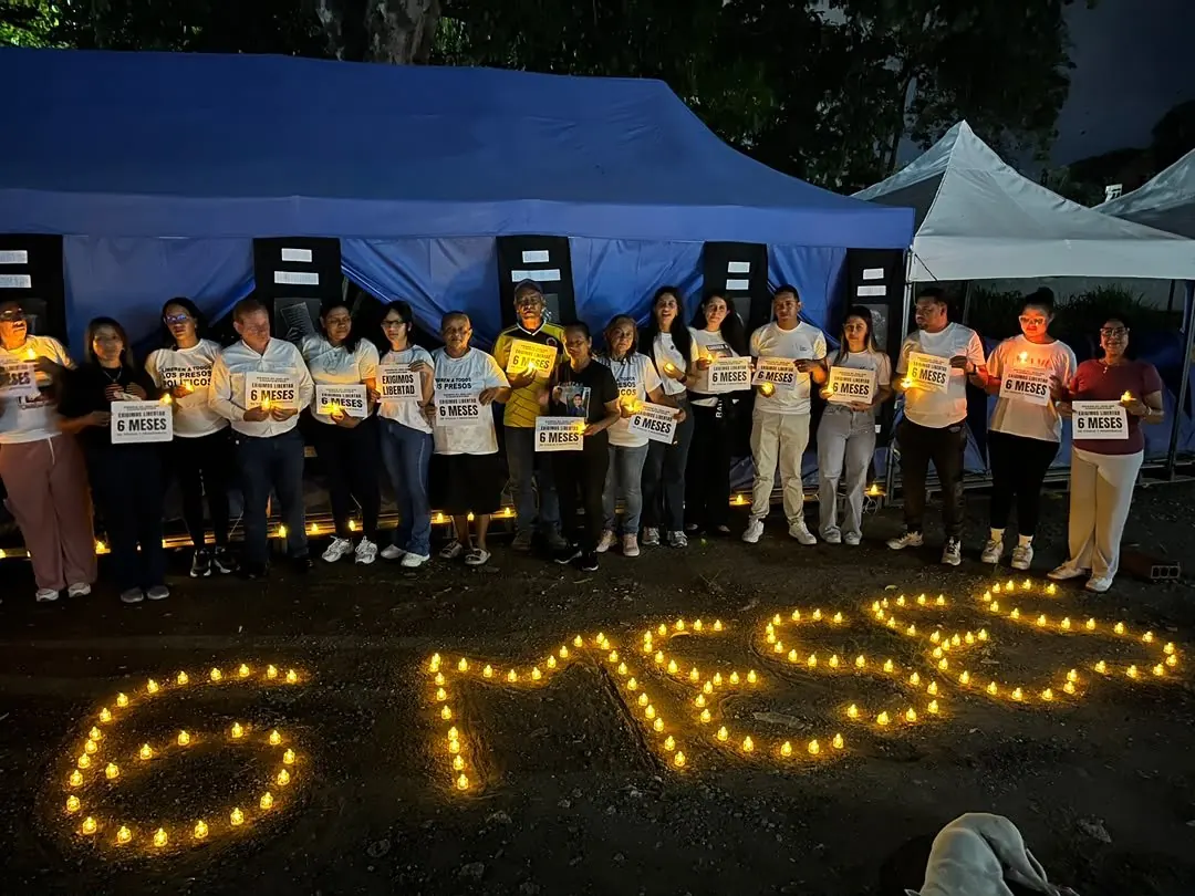 Grupo de personas manifestándose pacíficamente con pancartas frente a un centro penitenciario.