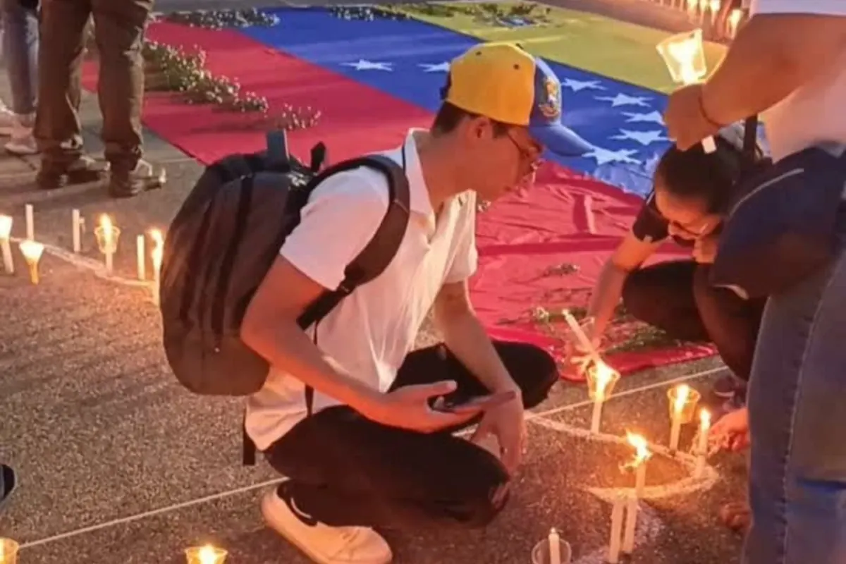 Comunidad de la Universidad Central de Venezuela reunida en una vigilia nocturna con velas, rindiendo homenaje a las víctimas de un terremoto.