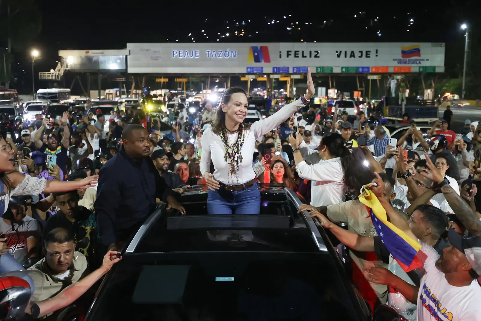 María Corina Machado saludando a sus seguidores desde un vehículo blindado durante su ingreso a Caracas el 25 de octubre de 2026